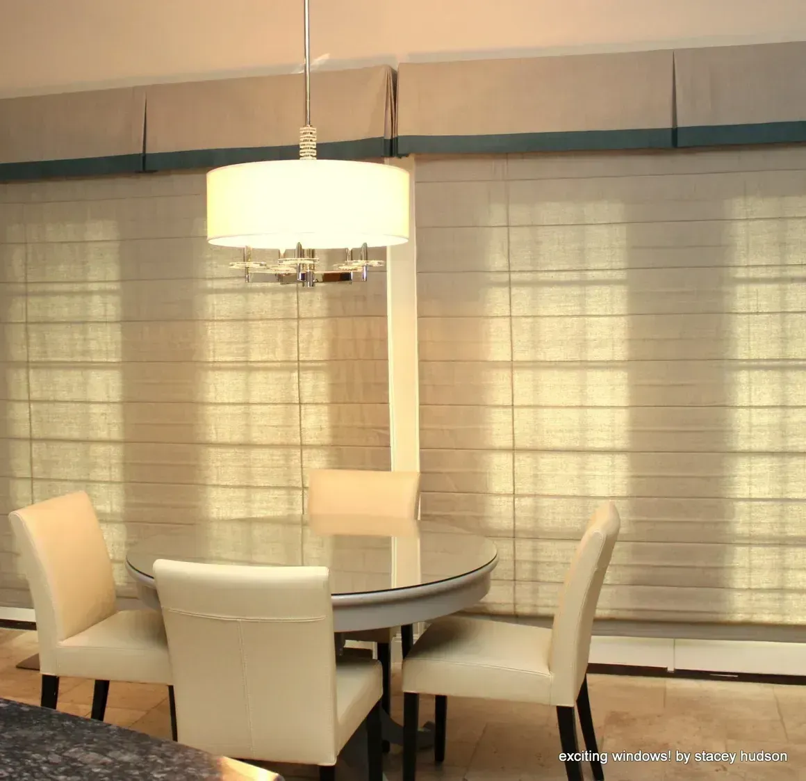 A dining room with a round table and white chairs