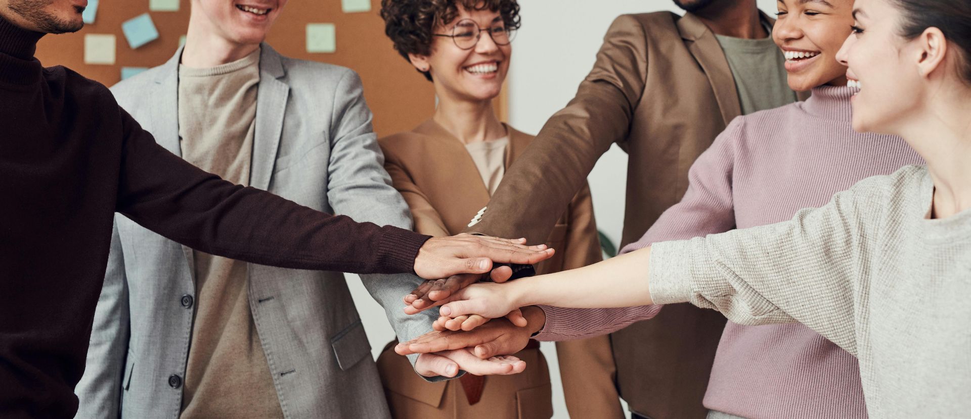 A group of people are putting their hands together in a huddle.