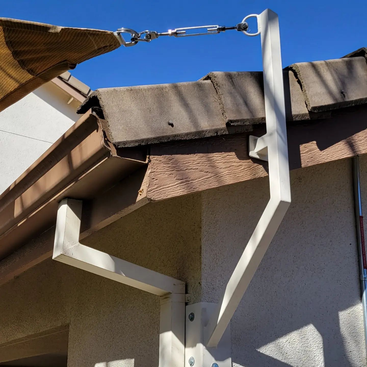 A white umbrella is attached to the side of a building