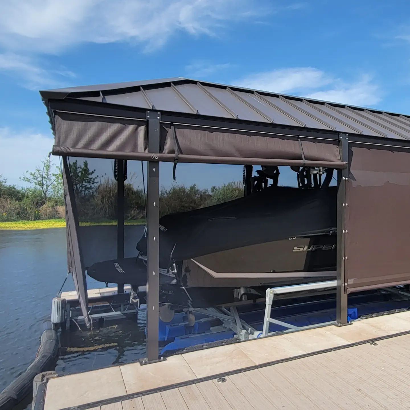 A boat is sitting in a covered dock next to a body of water