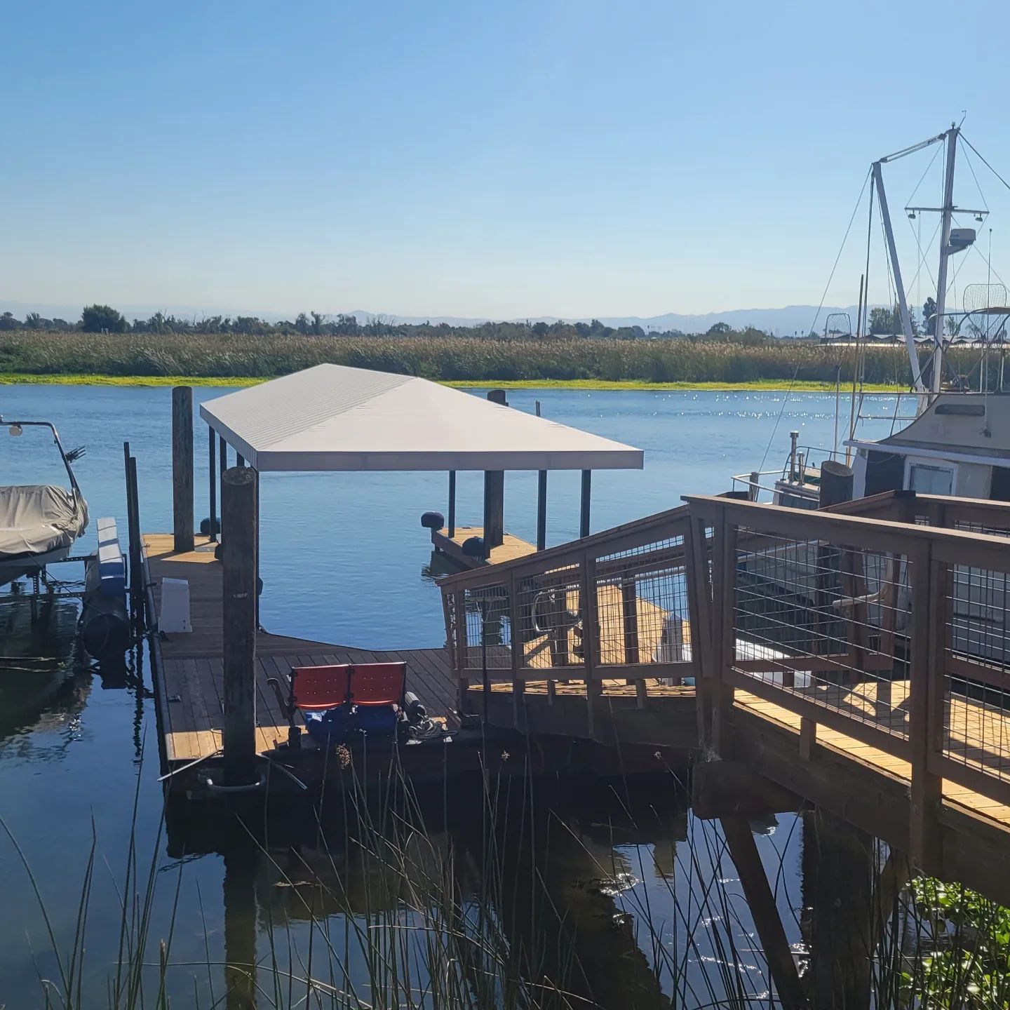 A boat is docked at a dock with a canopy over it
