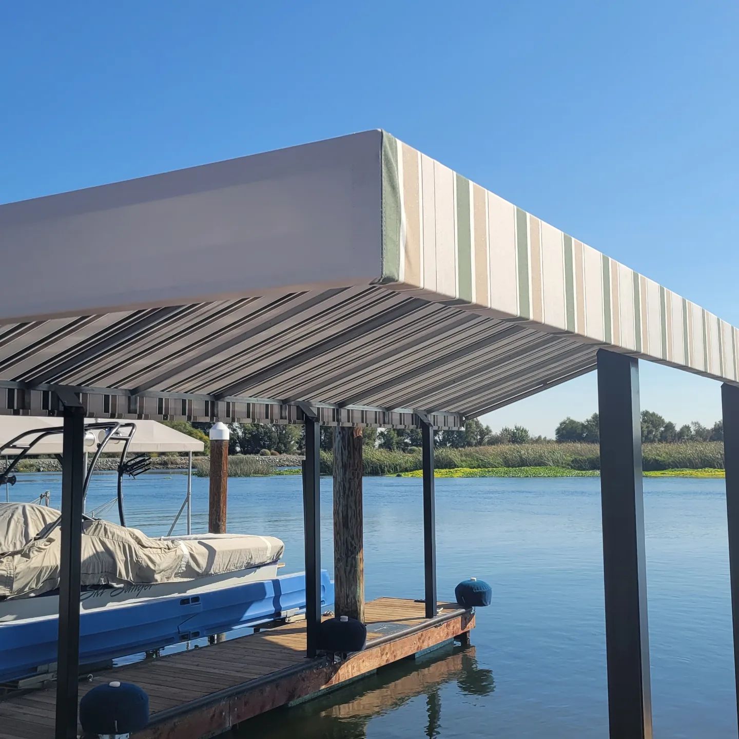 A boat is docked under a canopy in the water