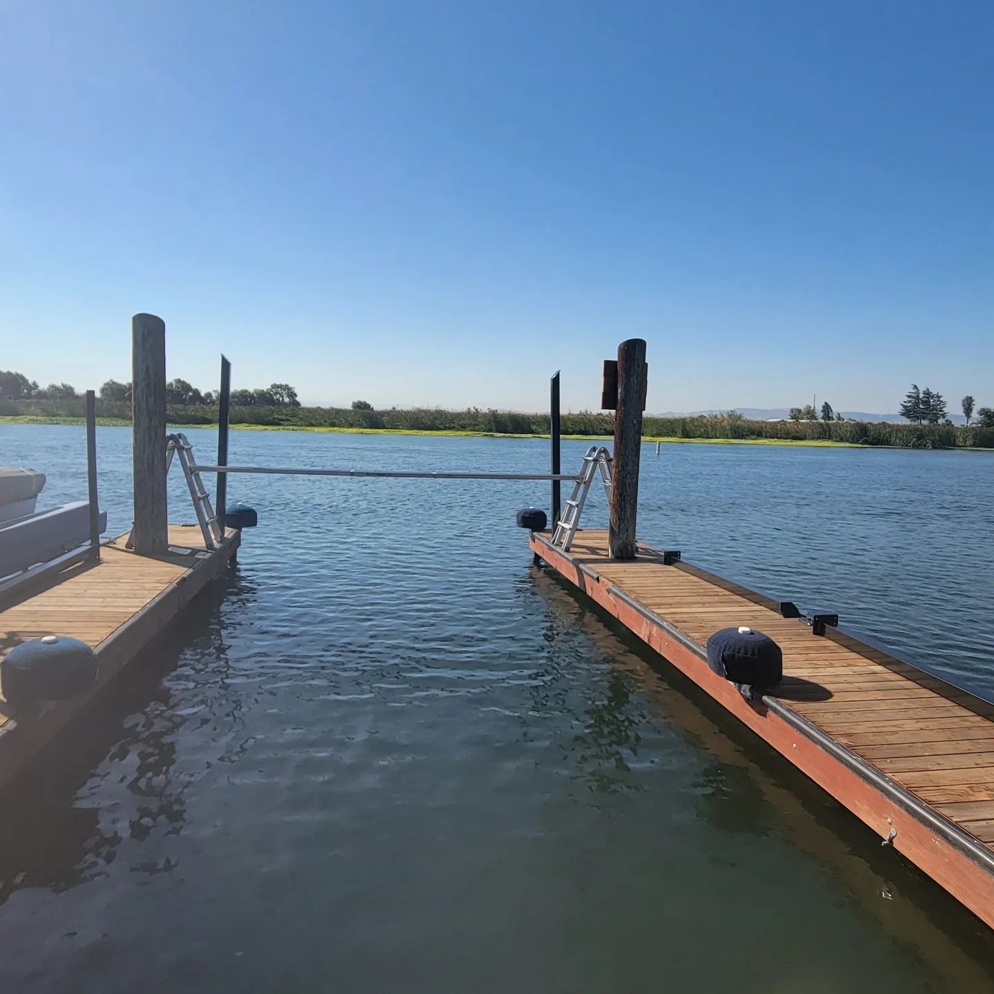 A boat is docked at a dock in the middle of a body of water.