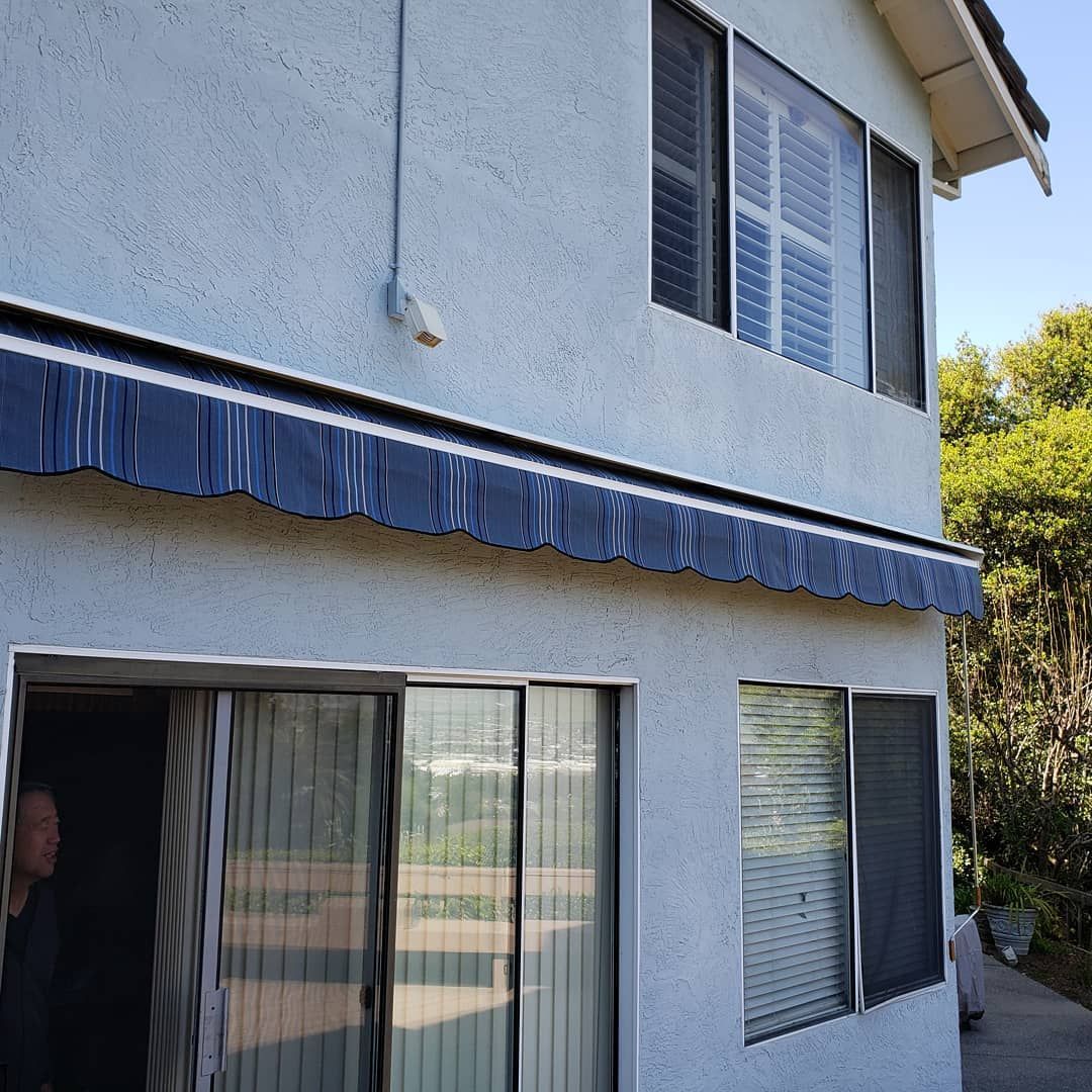 A house with a blue awning on the side of it