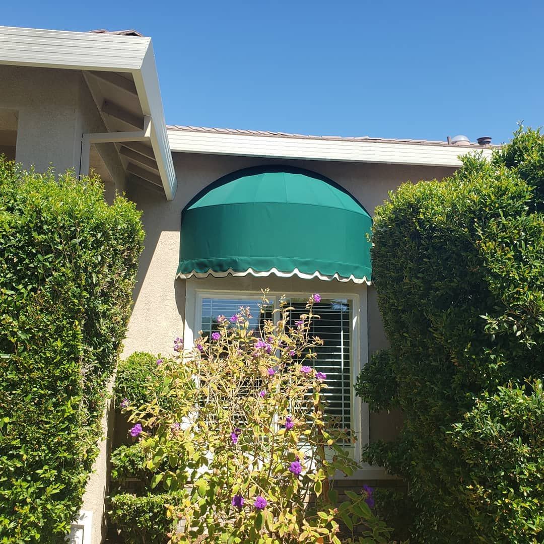 A house with a green awning over a window
