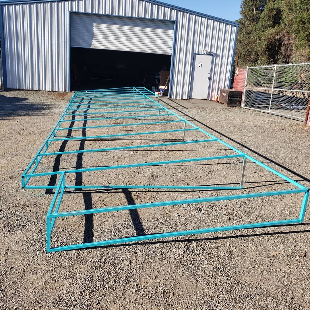 A blue metal frame is sitting on the ground in front of a building.