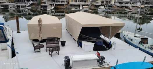 A boat is docked in a marina with a canopy over it.