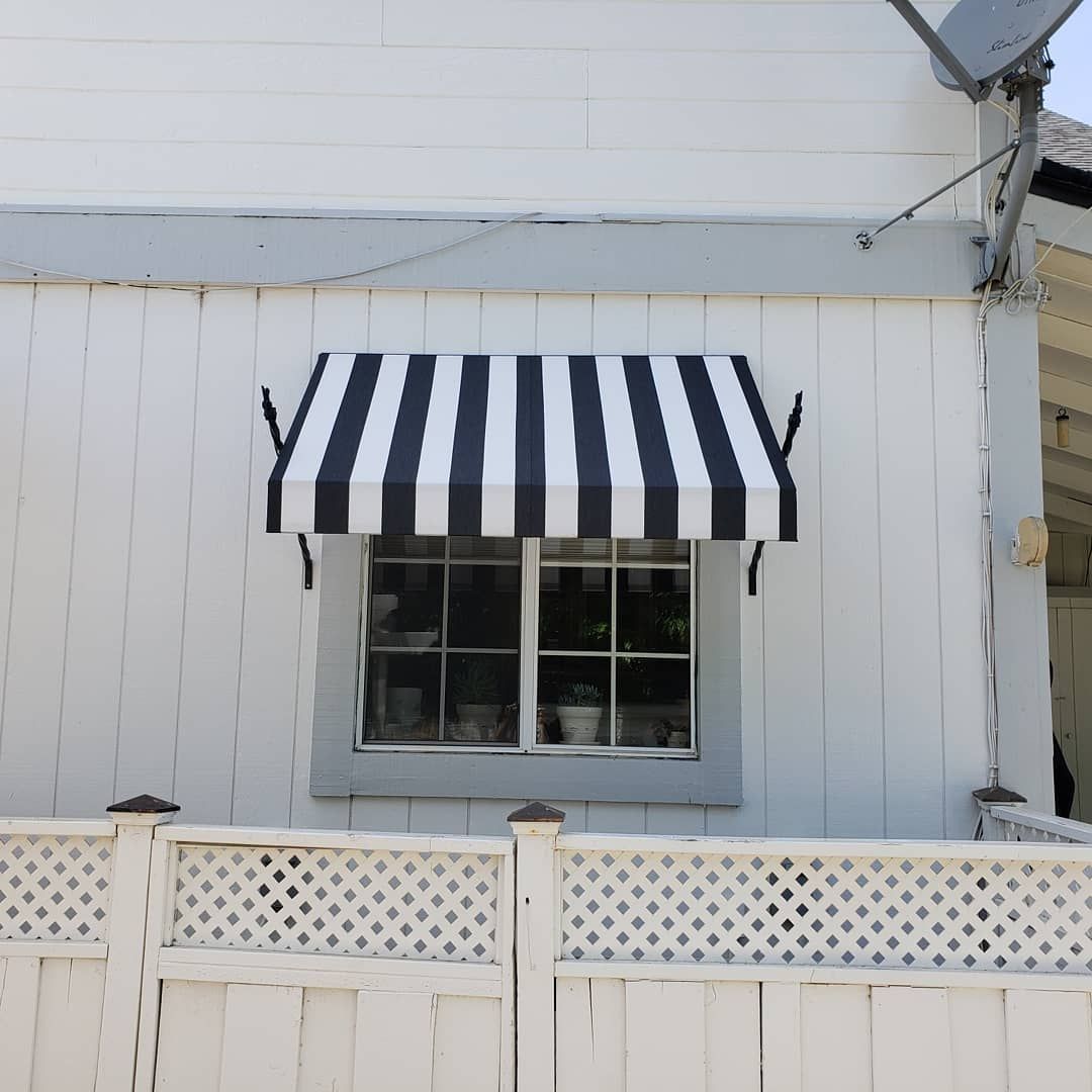 A black and white striped awning hangs over a window