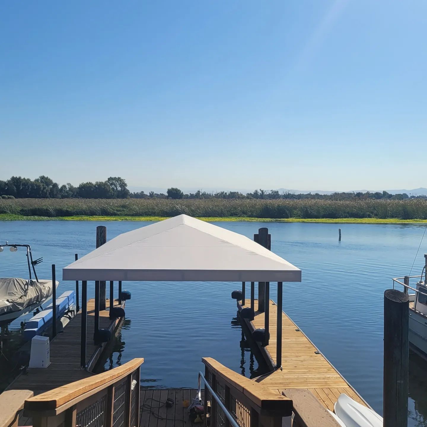 A boat is docked at a dock with a canopy over it
