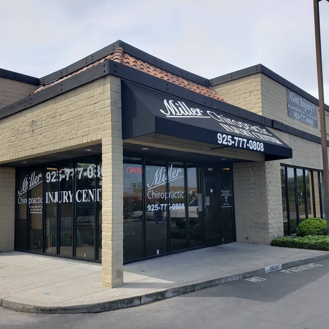 A large brick building with a black awning over the front door.