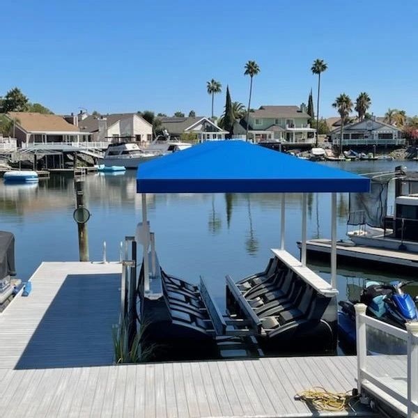 A boat with a blue canopy is docked at a dock