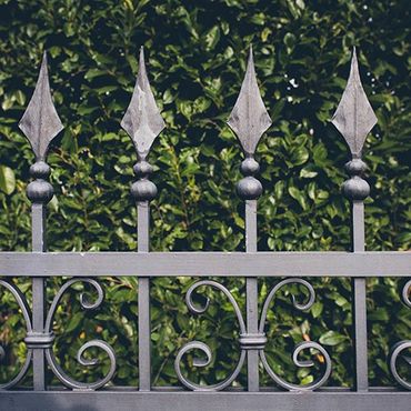 Iron Fence with Green Leaves on Background — Modesto, CA — Sam Farias Fencing, Inc