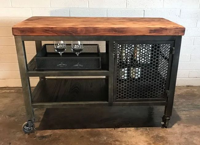 A wooden table with a metal frame and two wine glasses on it.