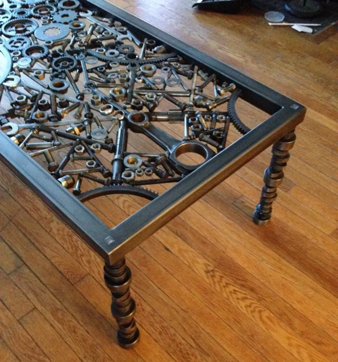 A coffee table made out of nuts and bolts on a wooden floor