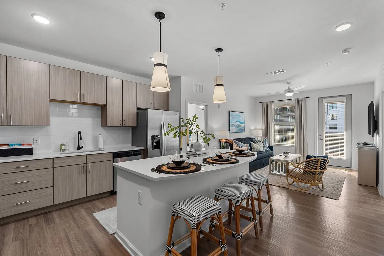 Open-concept apartment interior featuring a kitchen island, modern cabinetry, and living area.