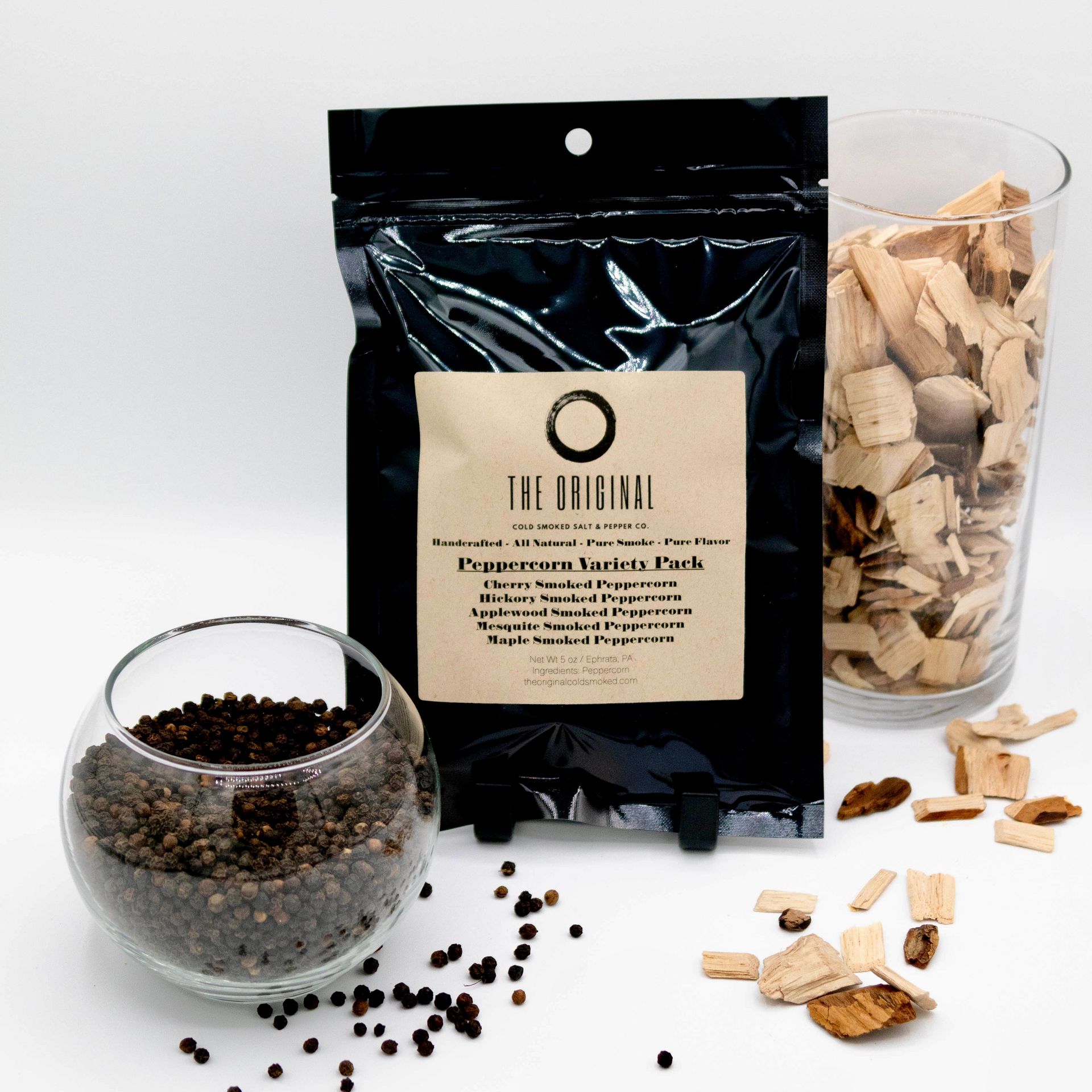 A bag of peppercorns next to a glass of peppercorns