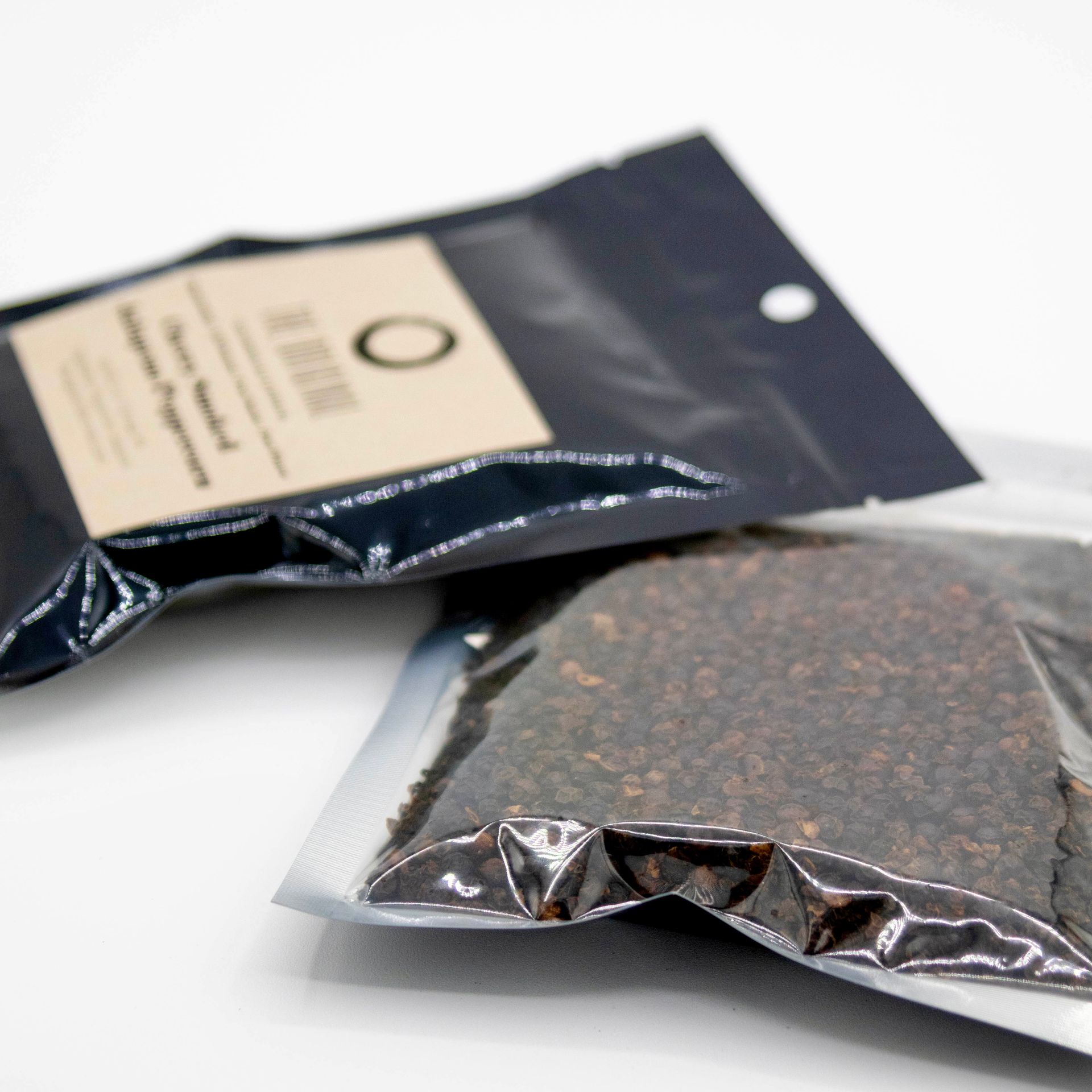 A bag of jalapenos next to a jar of wood chips