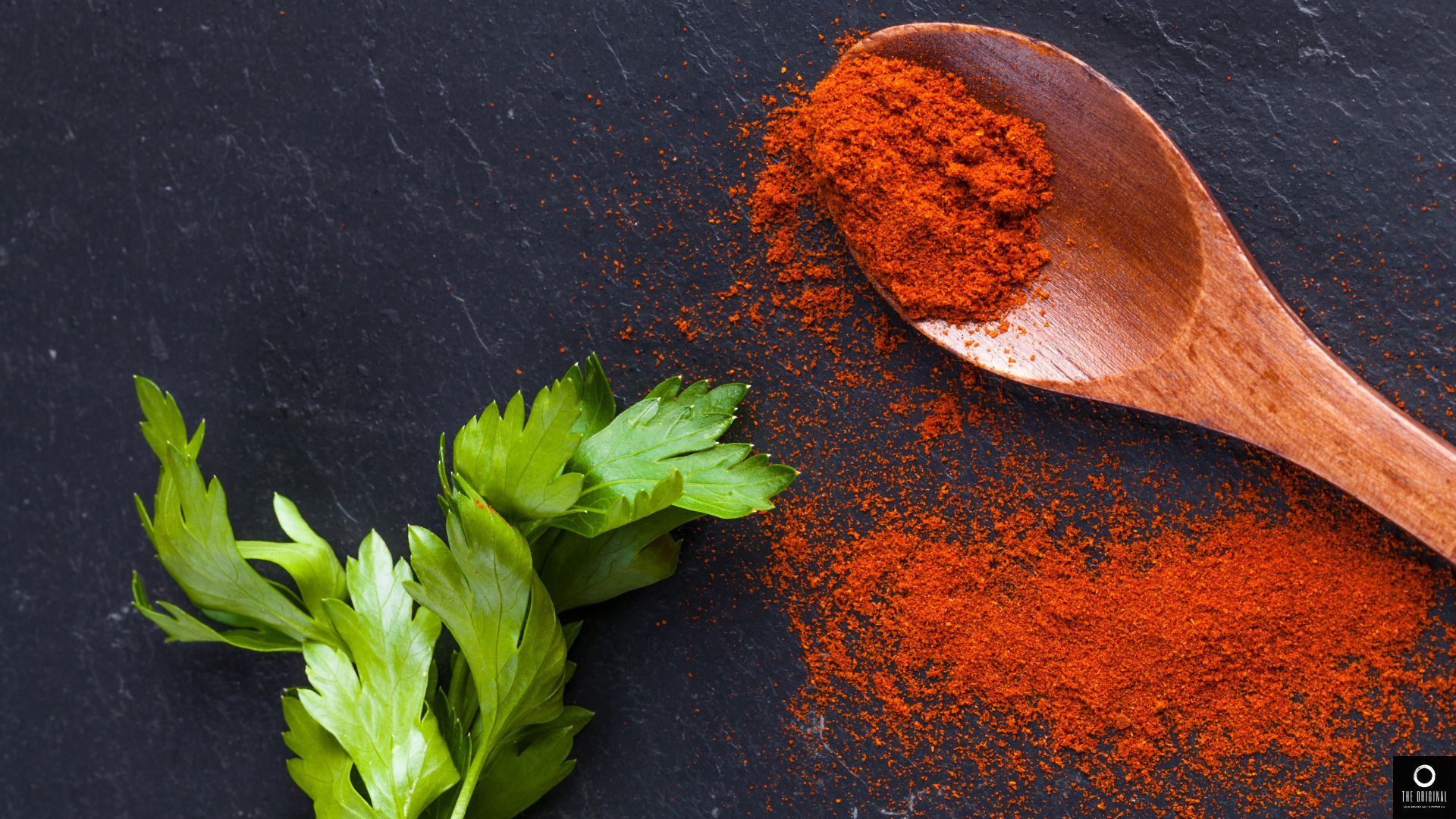 A wooden bowl filled with vegetables including peppers onions and lemons