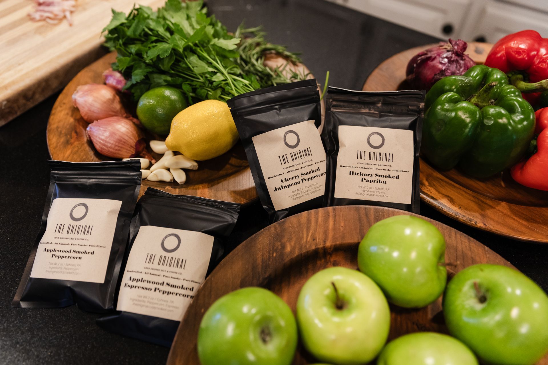 A bowl of green apples is sitting on a table next to a bowl of vegetables.