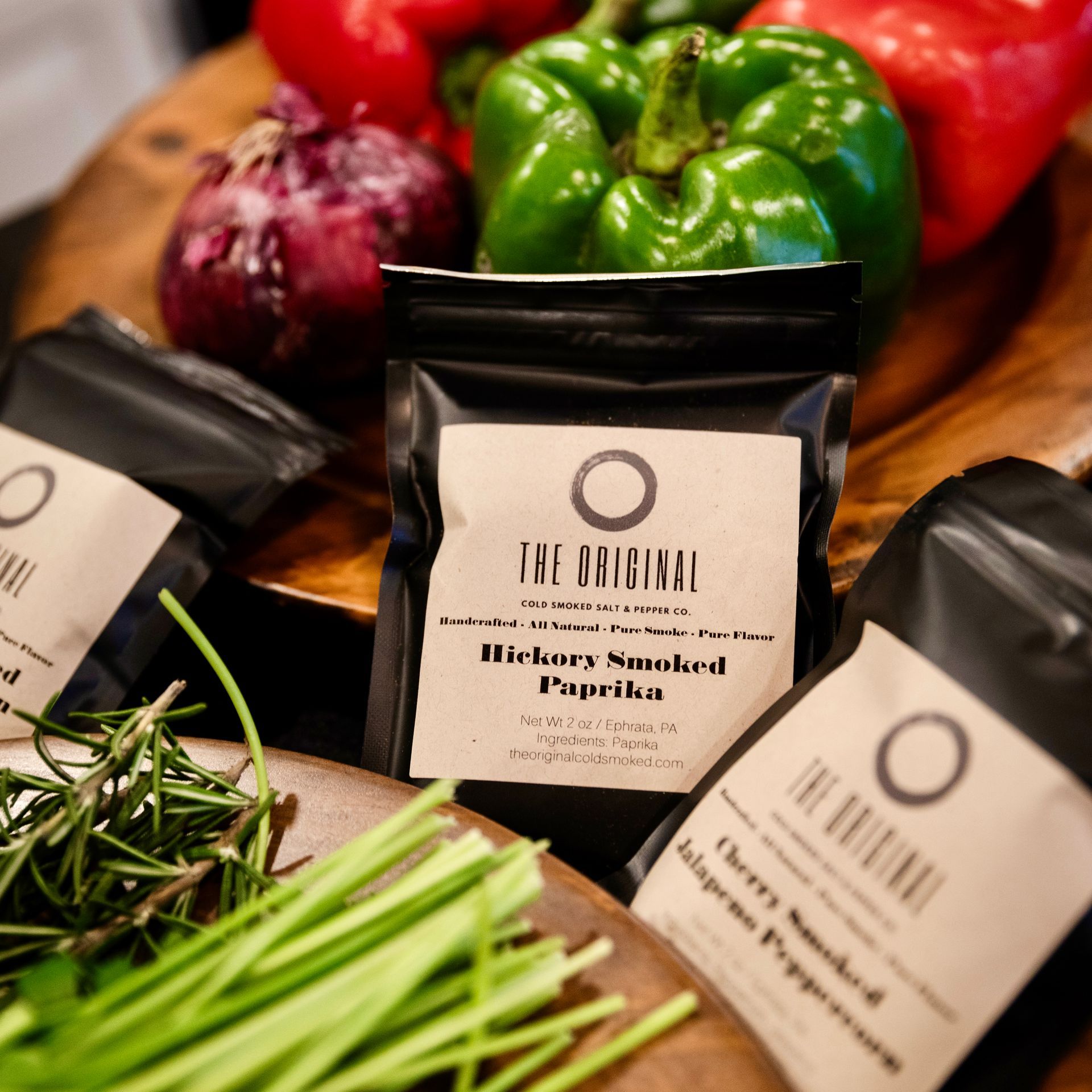 Three bags of the original dietary smoked paprika sit on a wooden cutting board