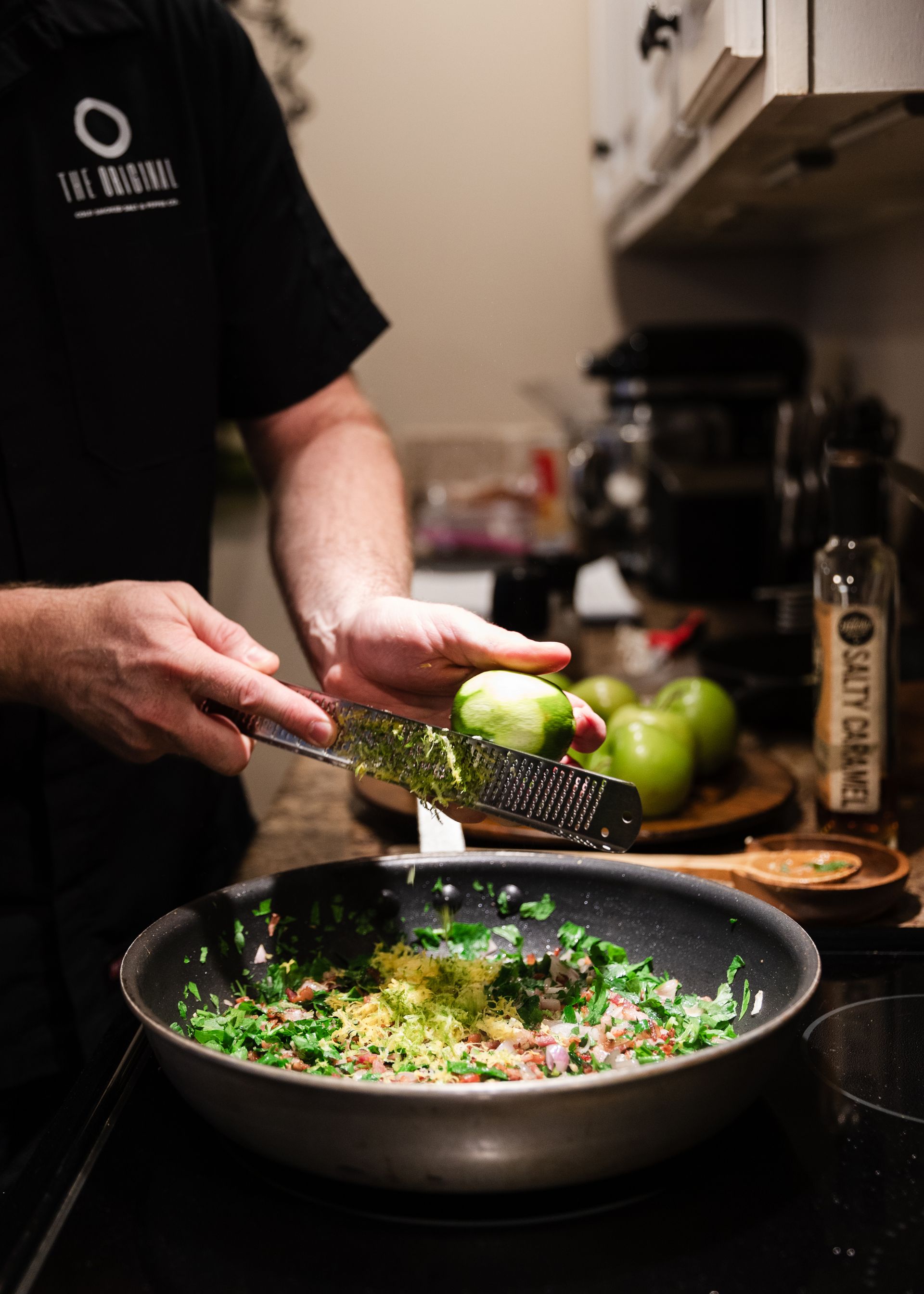 A man is cooking food in a pan in a kitchen.