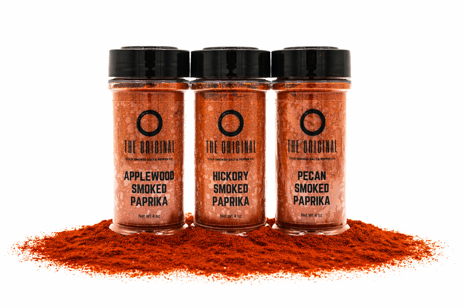 Three spice jars labeled smoked paprika, paprika pepper, and chili, with paprika powder spilled beneath them.