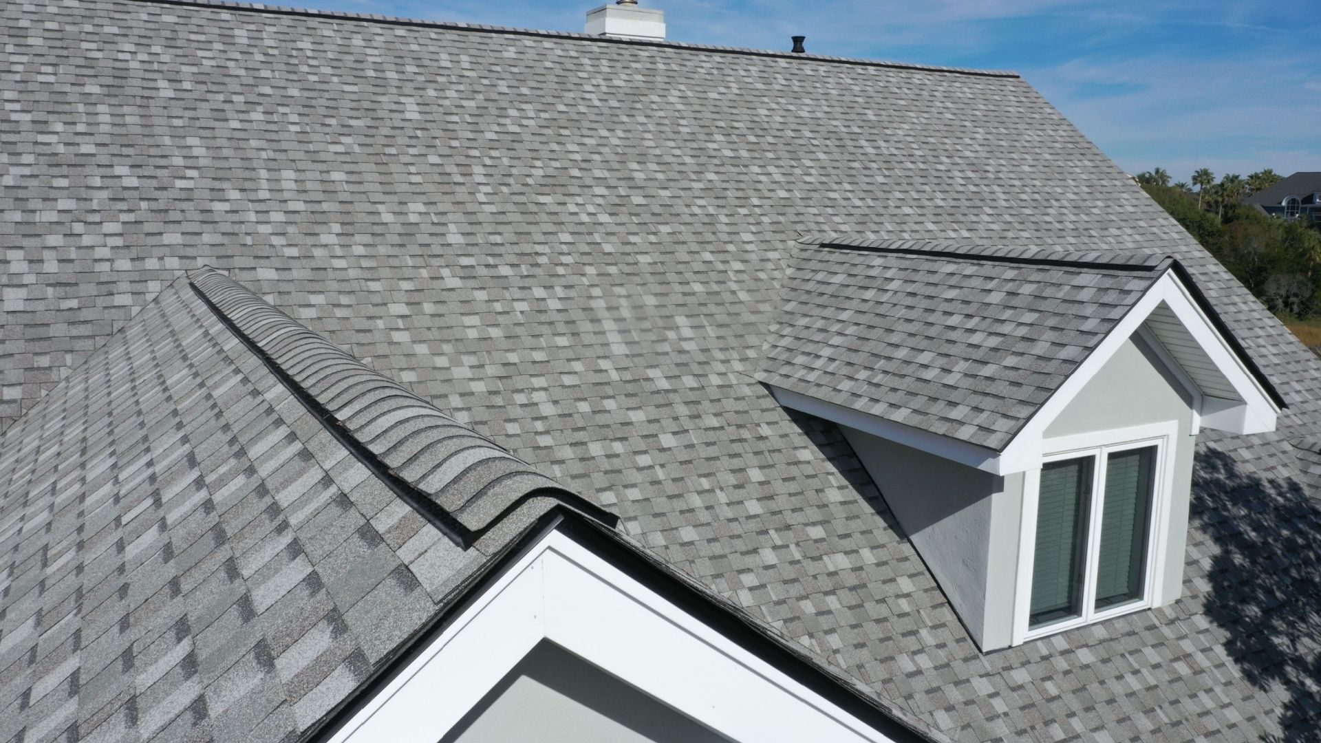 A house with a gray roof and a window on the roof.