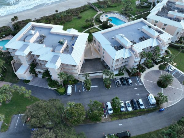 An aerial view of a building with cars parked in front of it