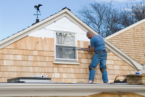 A man is working on the roof of a house