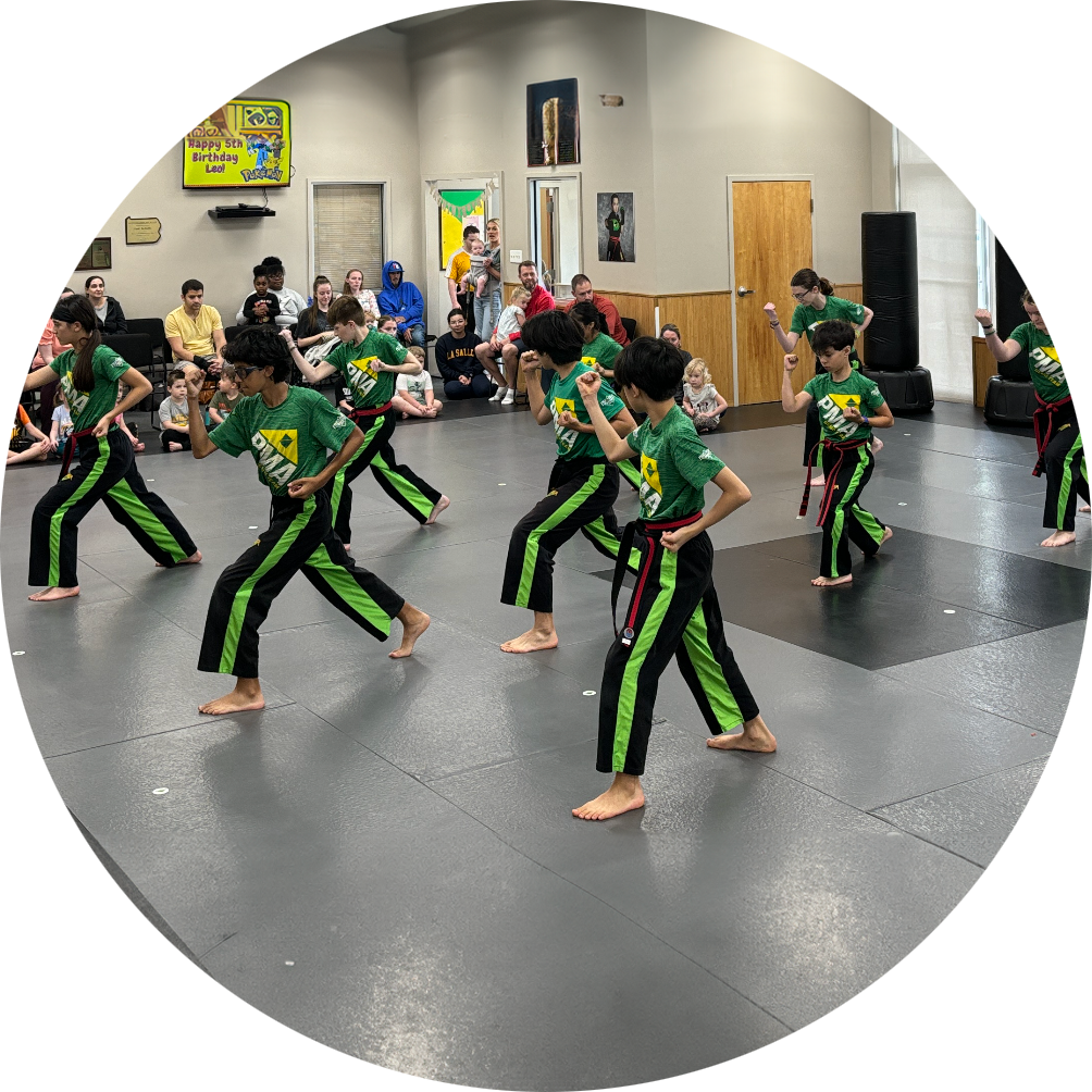 A group of children are practicing karate in a gym.