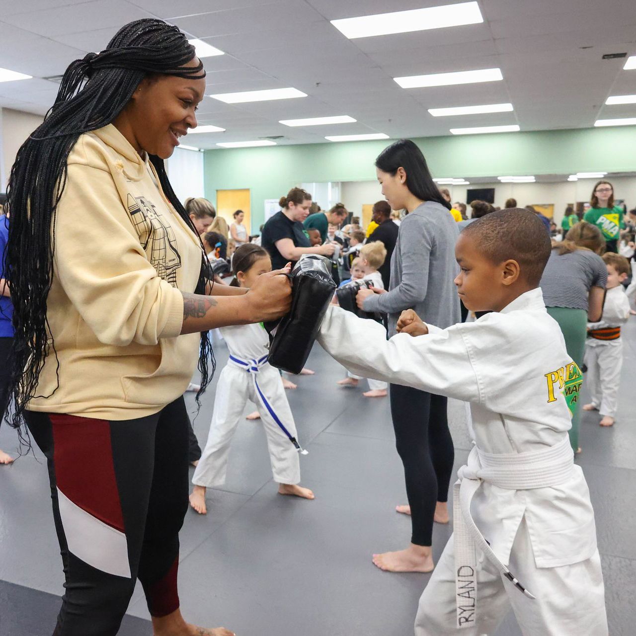 A group of children are practicing martial arts in a gym