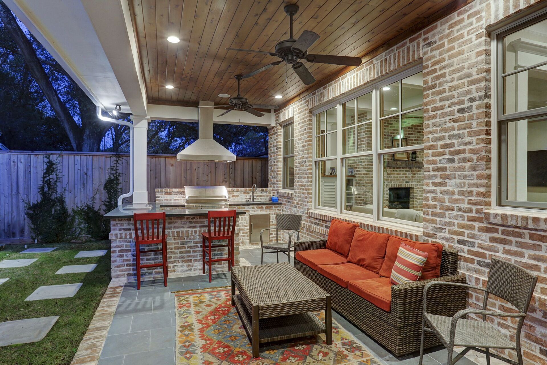 A patio with a couch , table , chairs and a ceiling fan.