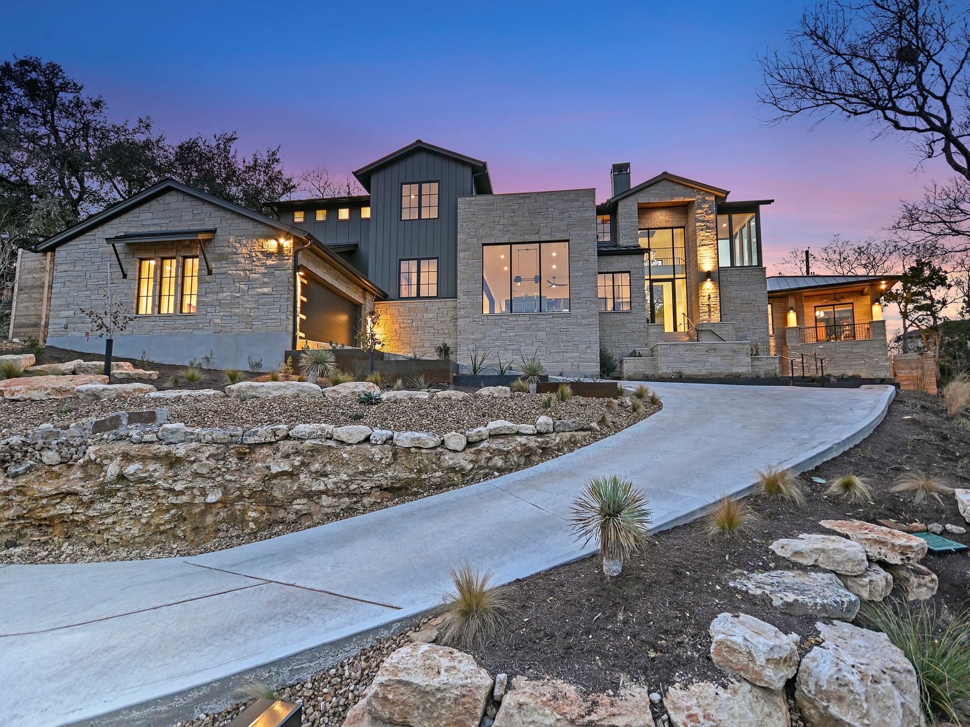 A large house with a lot of windows is sitting on top of a hill.