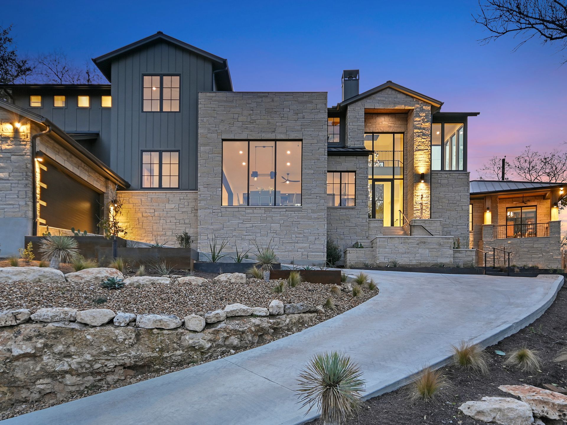 A large house with a lot of windows is sitting on top of a hill.