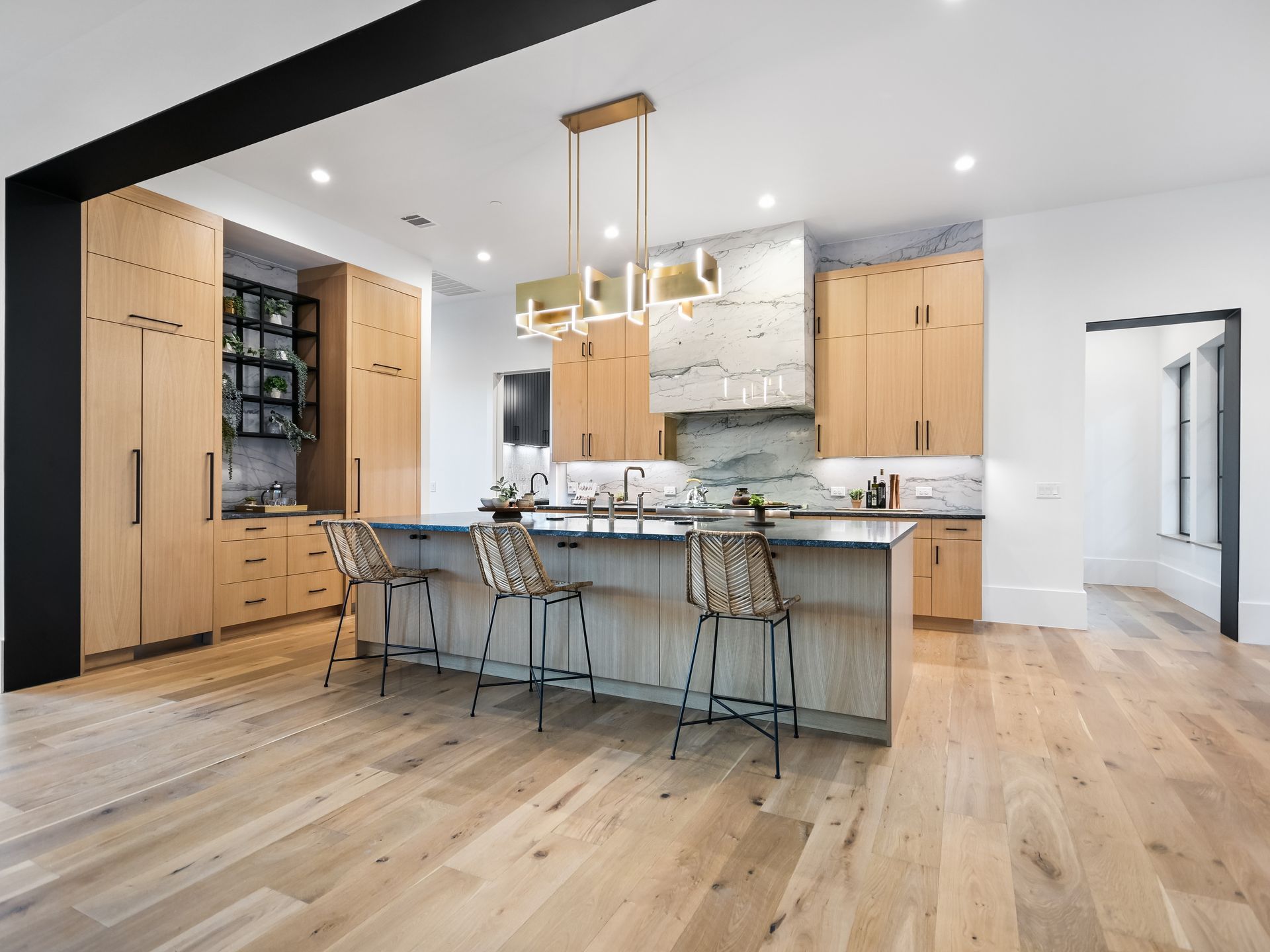 A kitchen with a large island and wooden floors.
