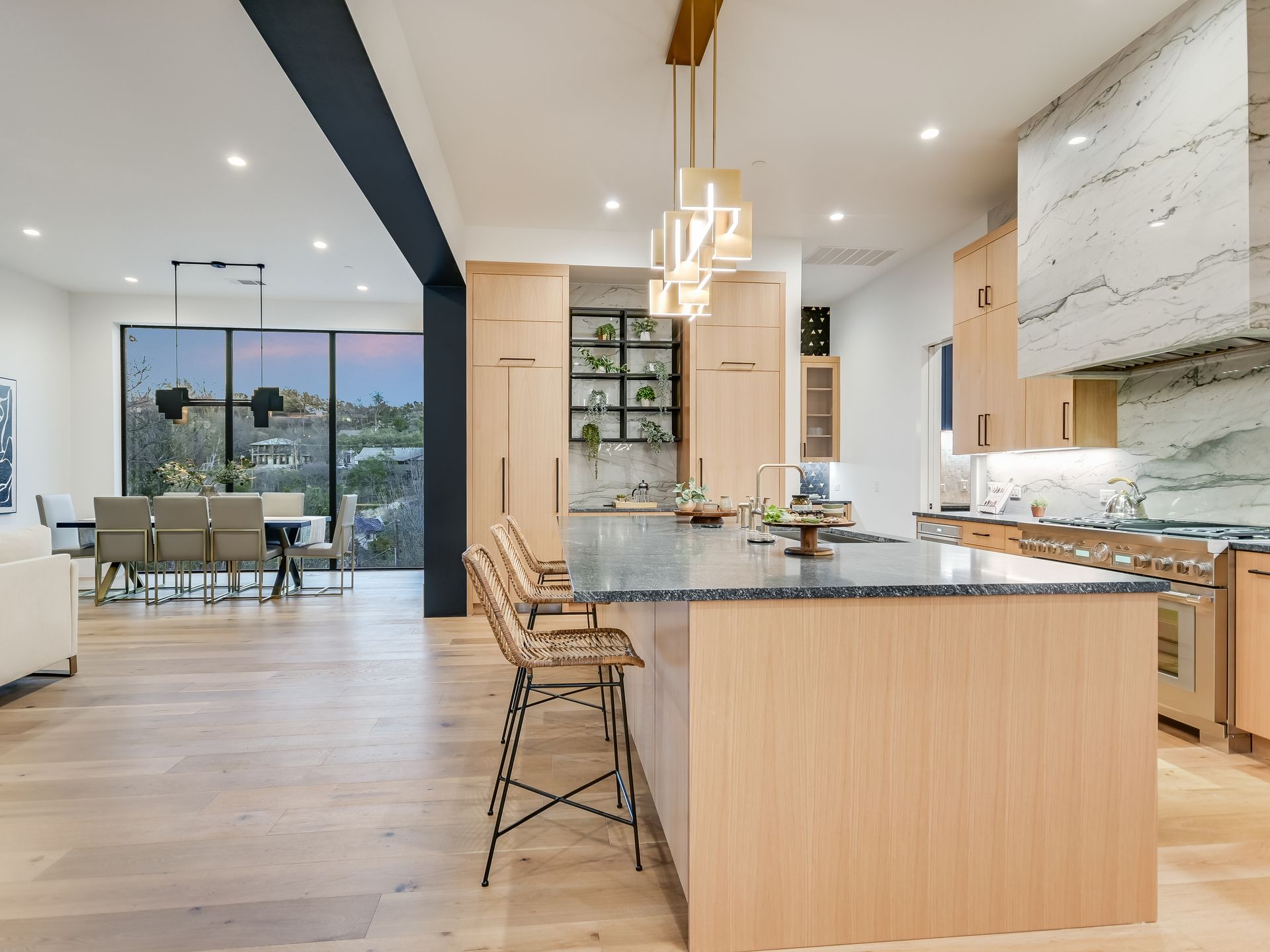 A kitchen with a large island and a dining room in the background.