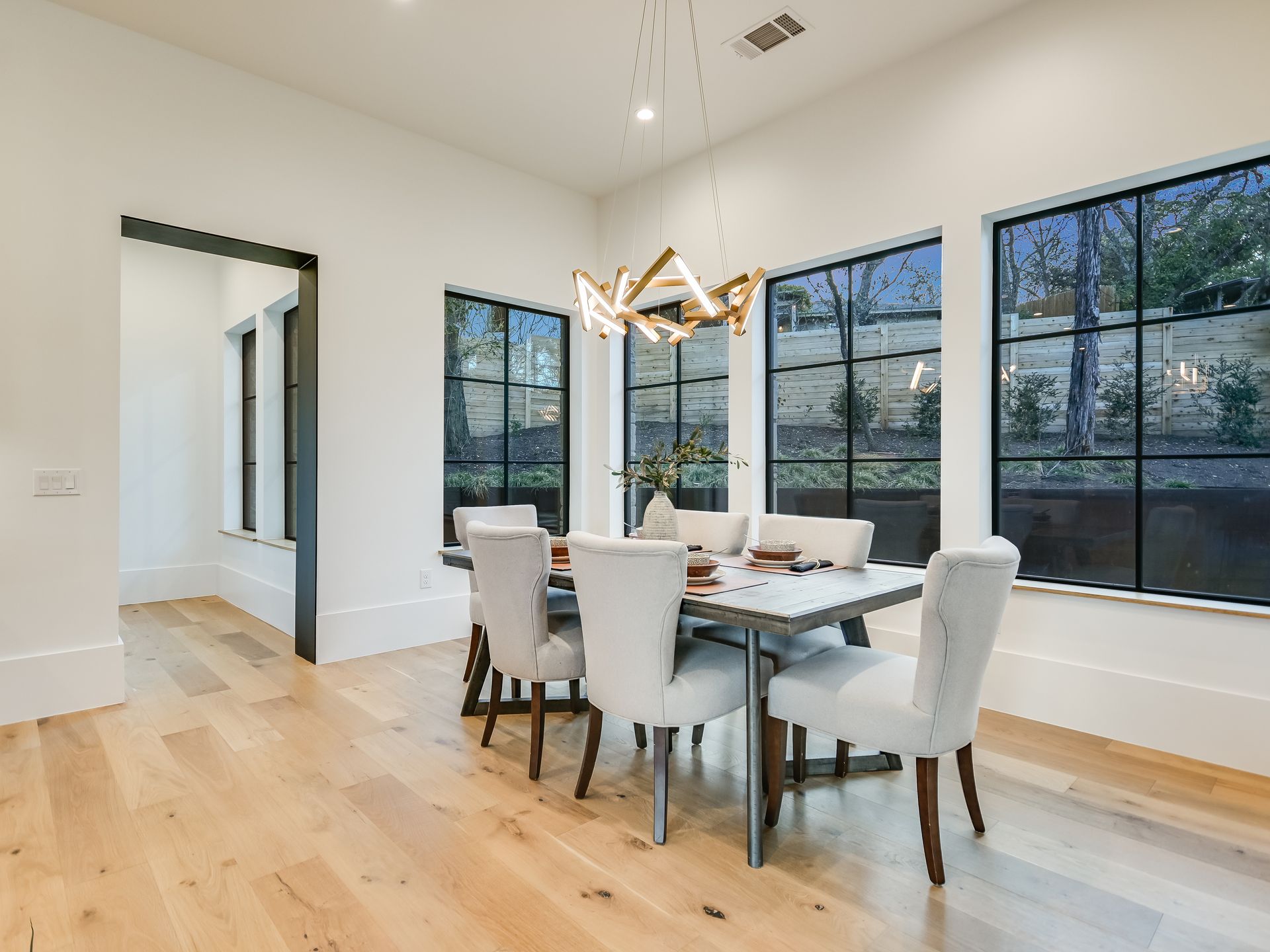 A dining room with a table and chairs and a chandelier.