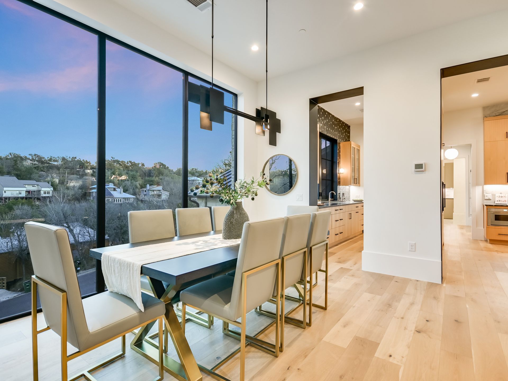 A dining room with a table and chairs and a large window.