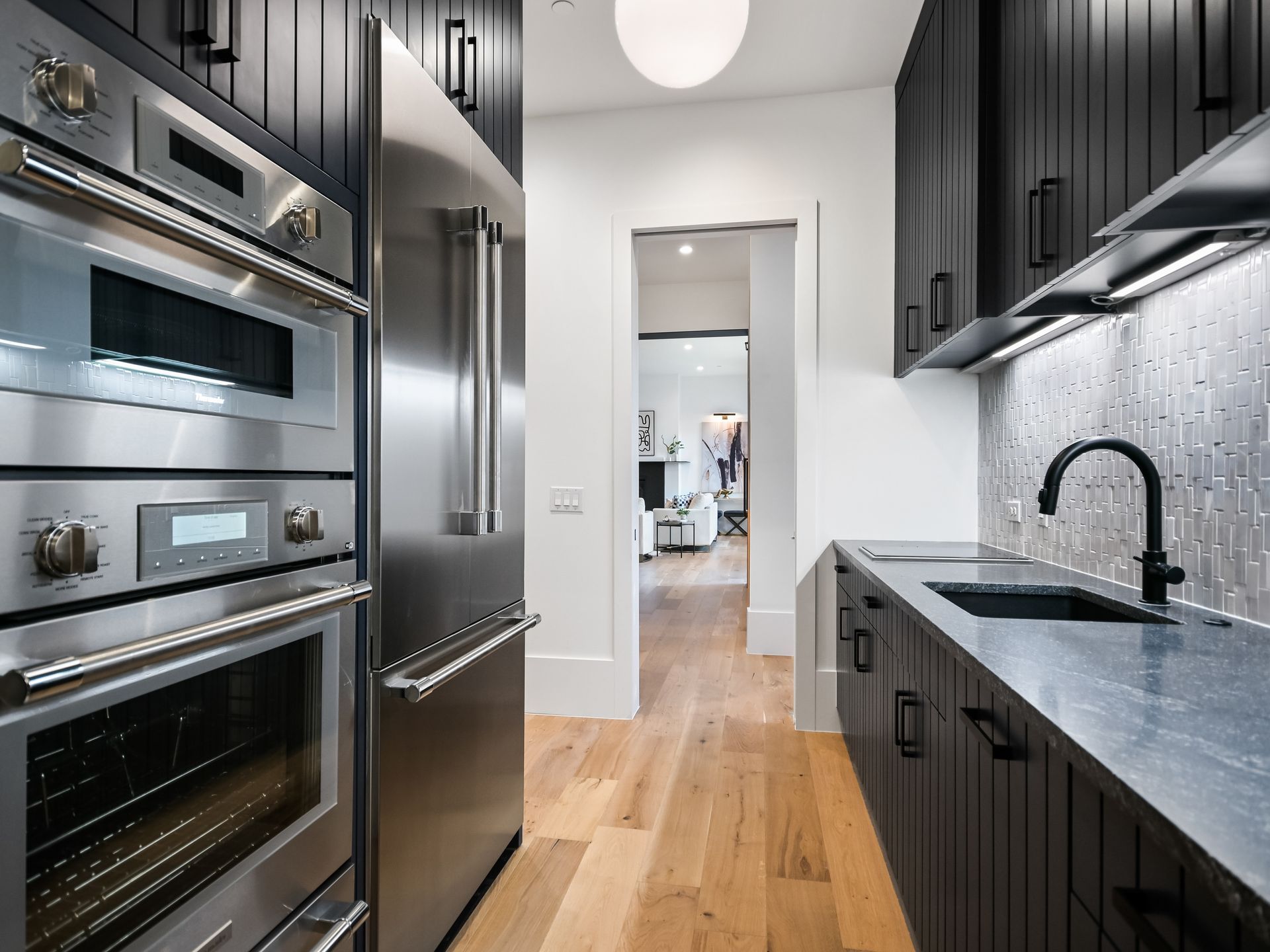 A kitchen with stainless steel appliances and black cabinets