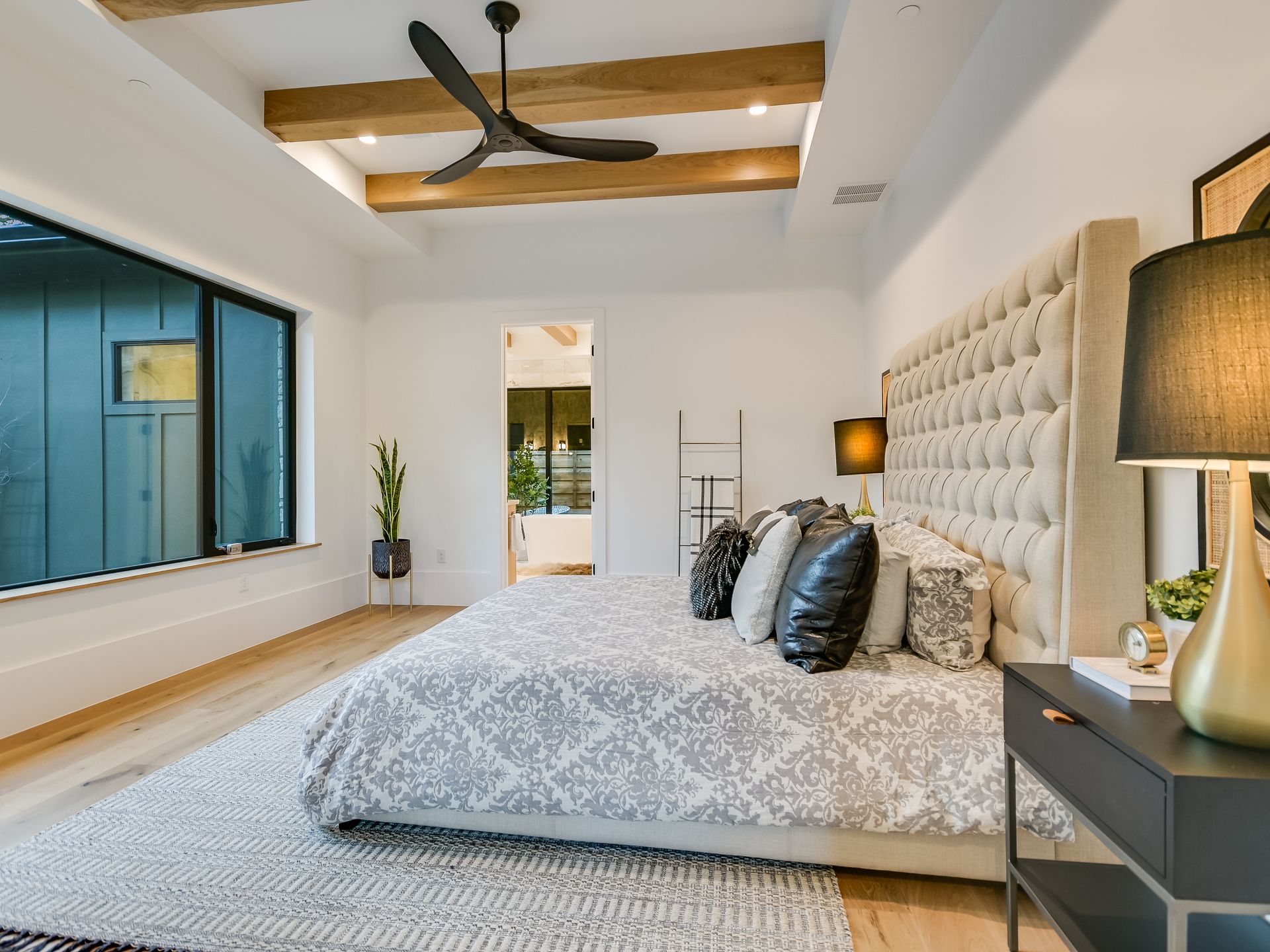 A bedroom with a large bed and a ceiling fan.