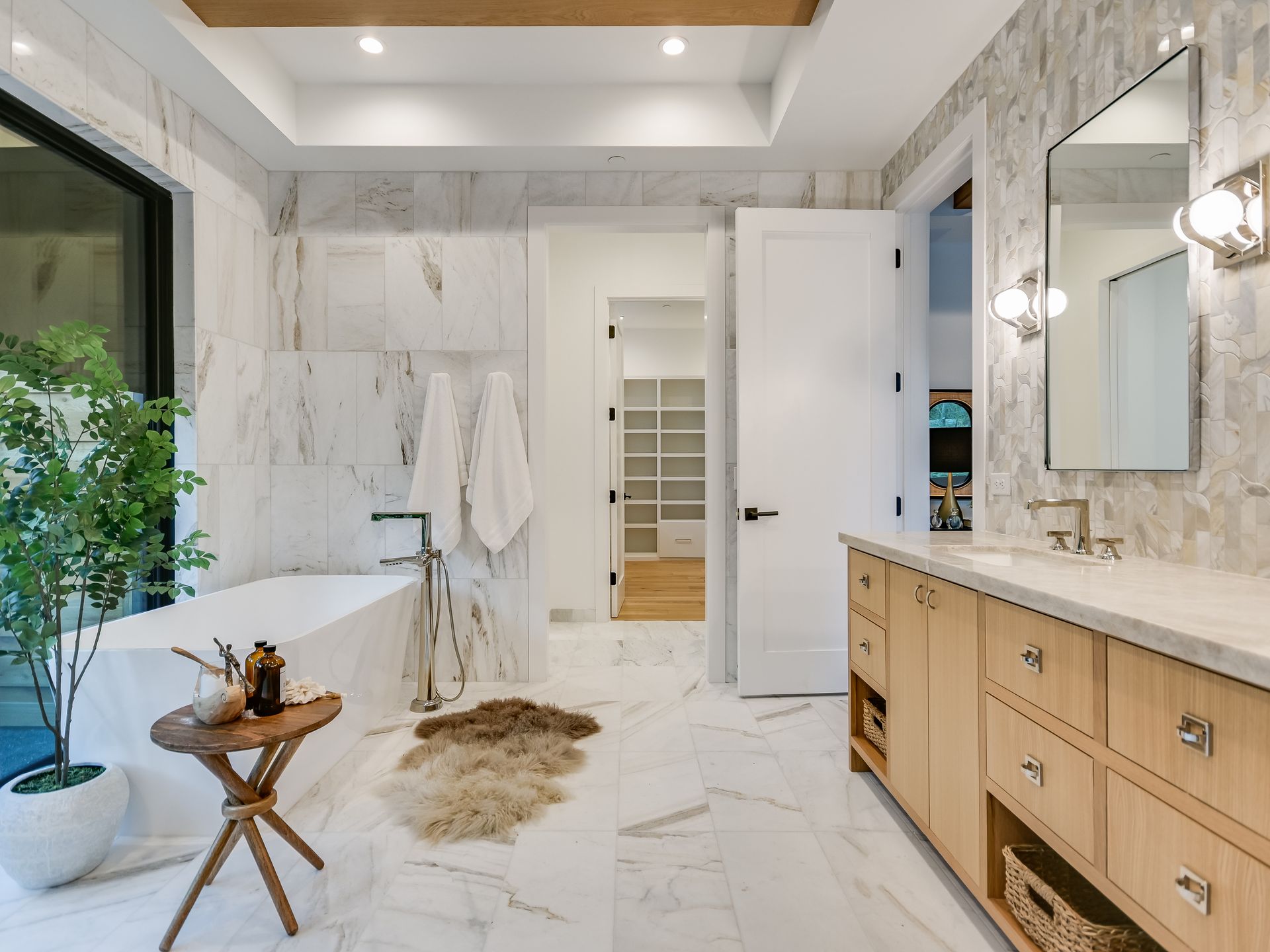 A bathroom with a tub , sink and mirror.