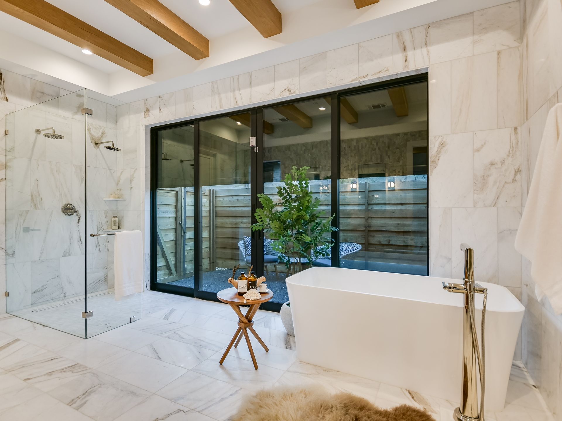 A bathroom with a tub , shower , and sliding glass doors.