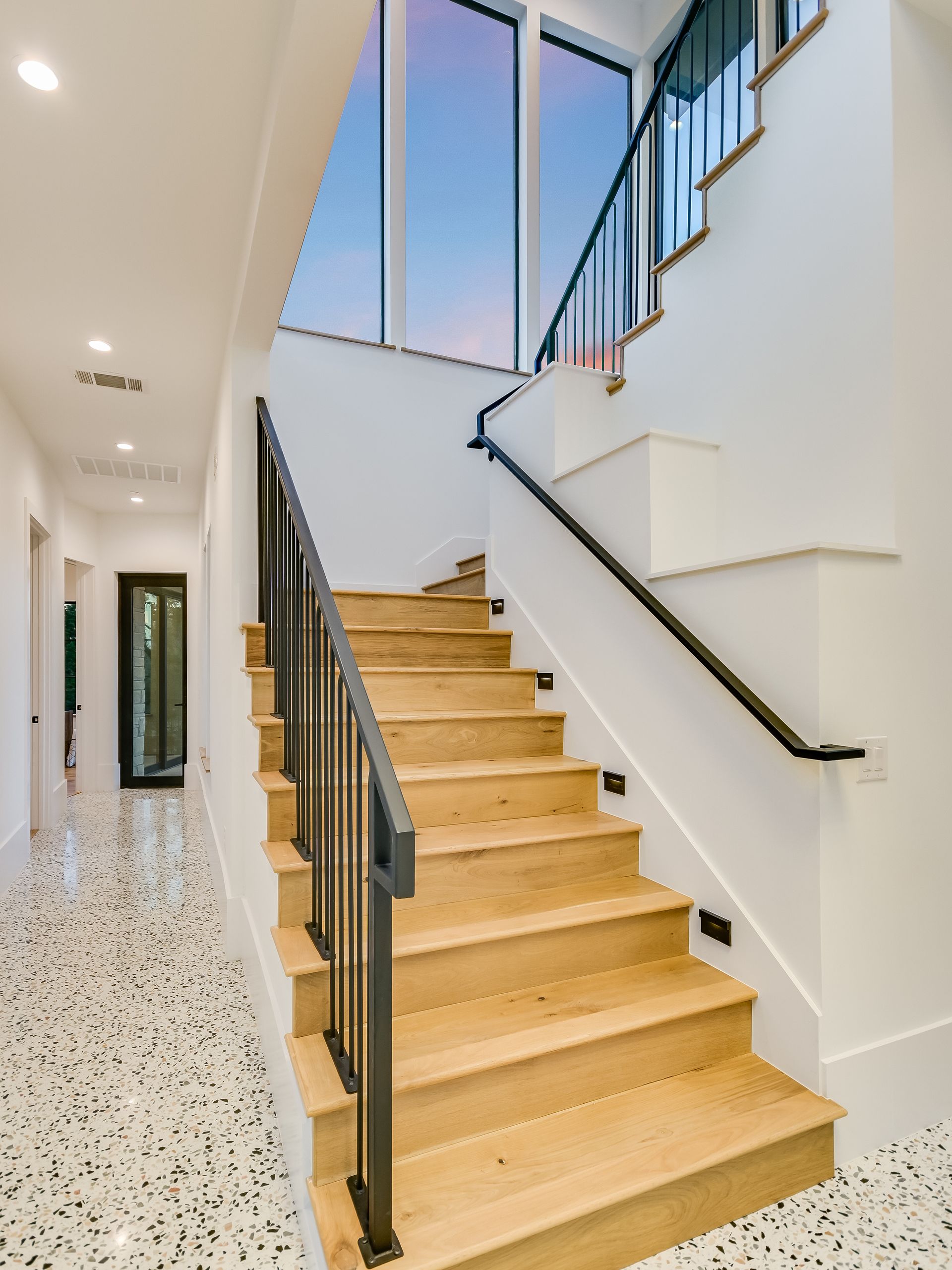 A staircase with wooden steps and a black railing