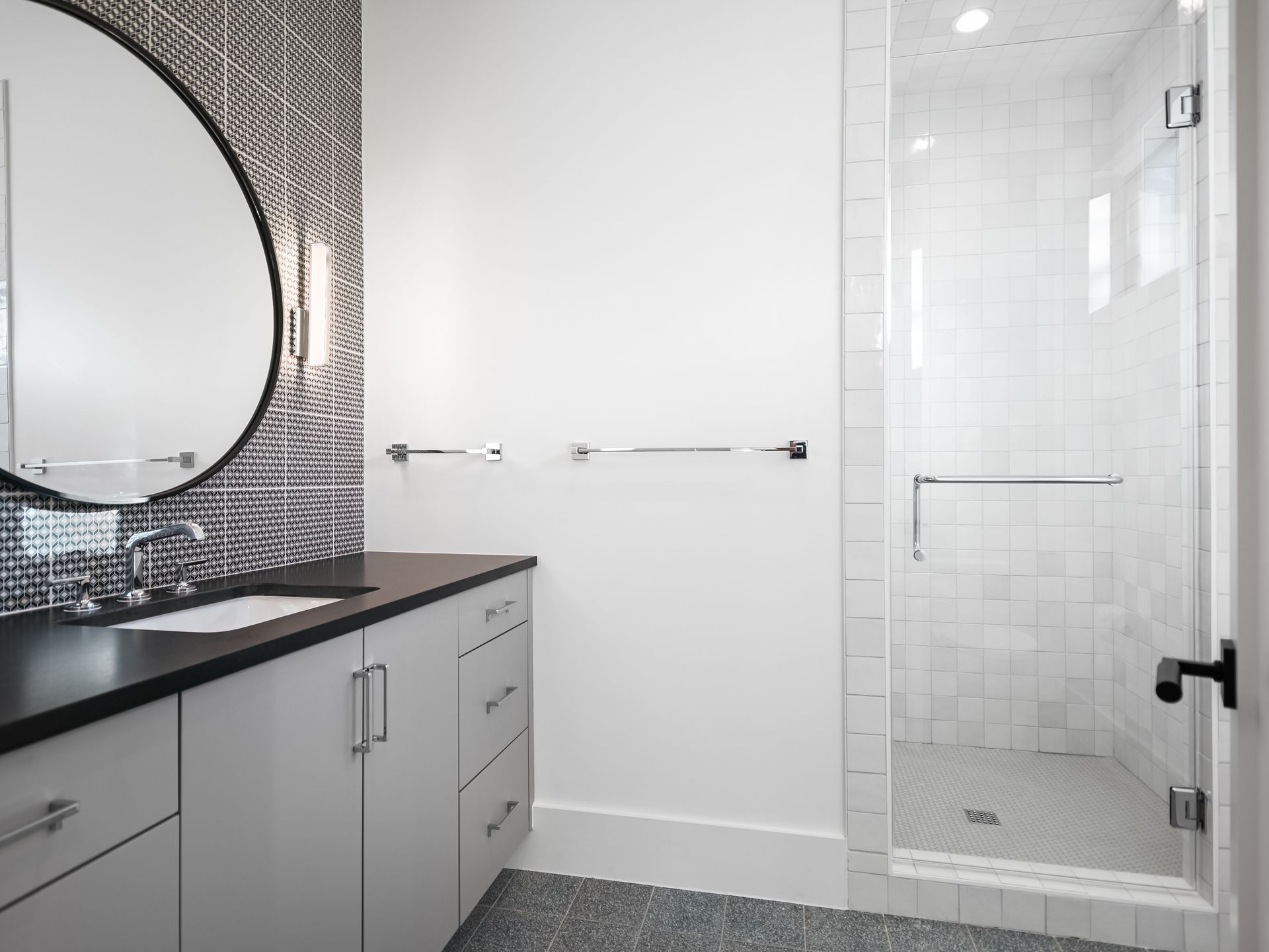 A bathroom with a sink , mirror , and walk in shower.