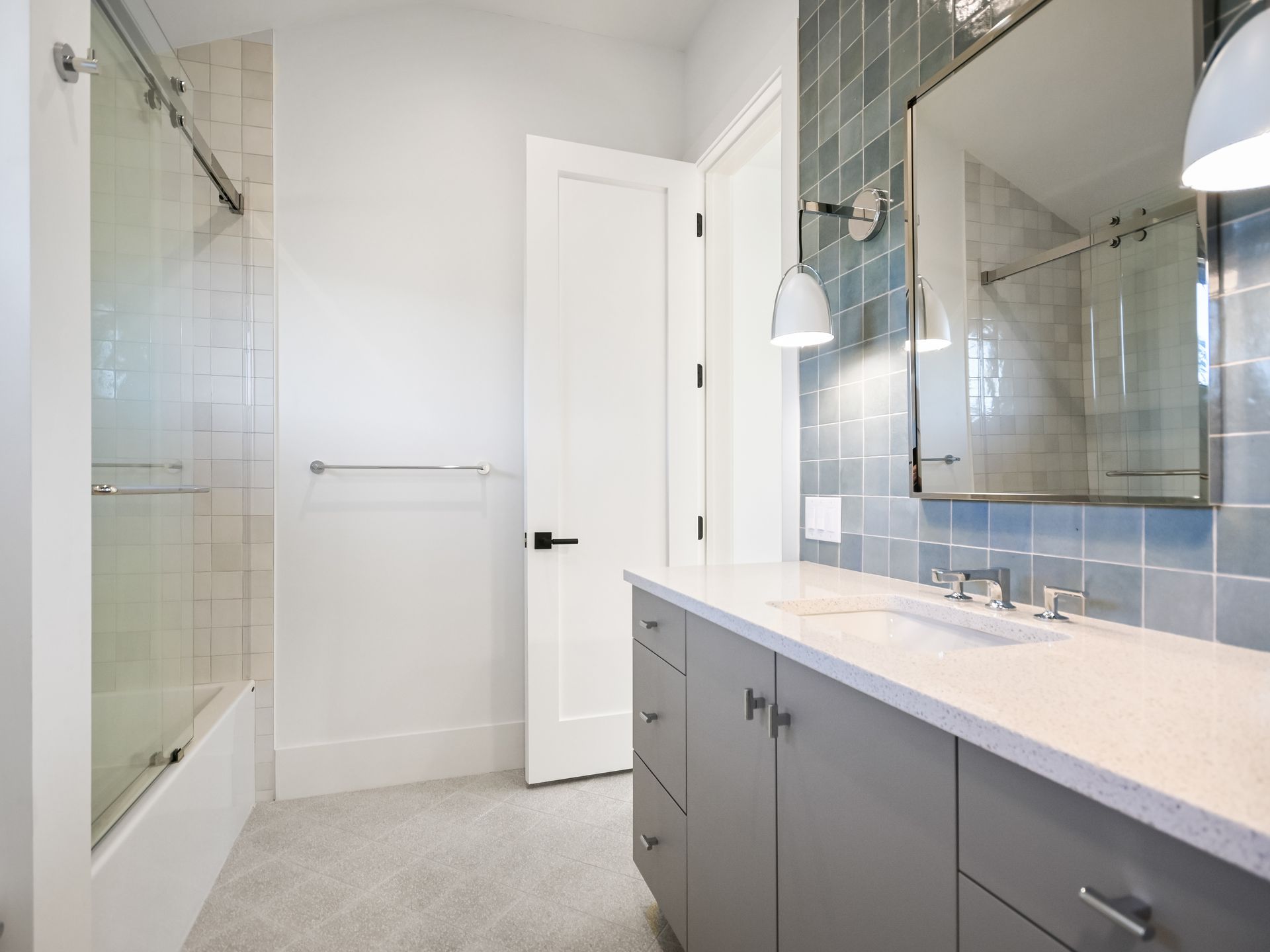 A bathroom with a sink , mirror , tub and shower.