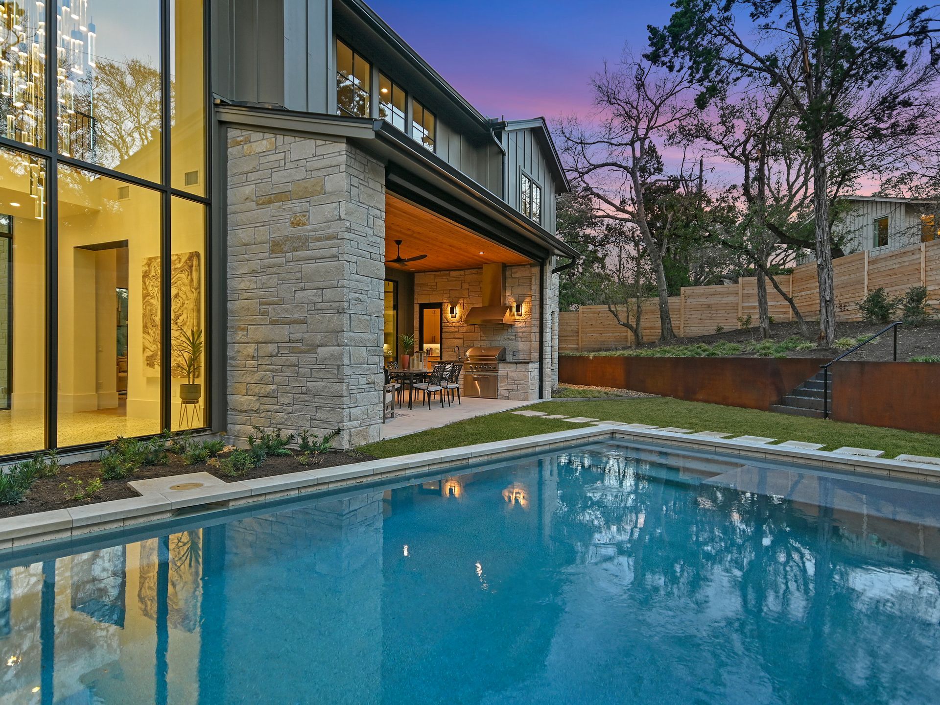 There is a large swimming pool in the backyard of a house.