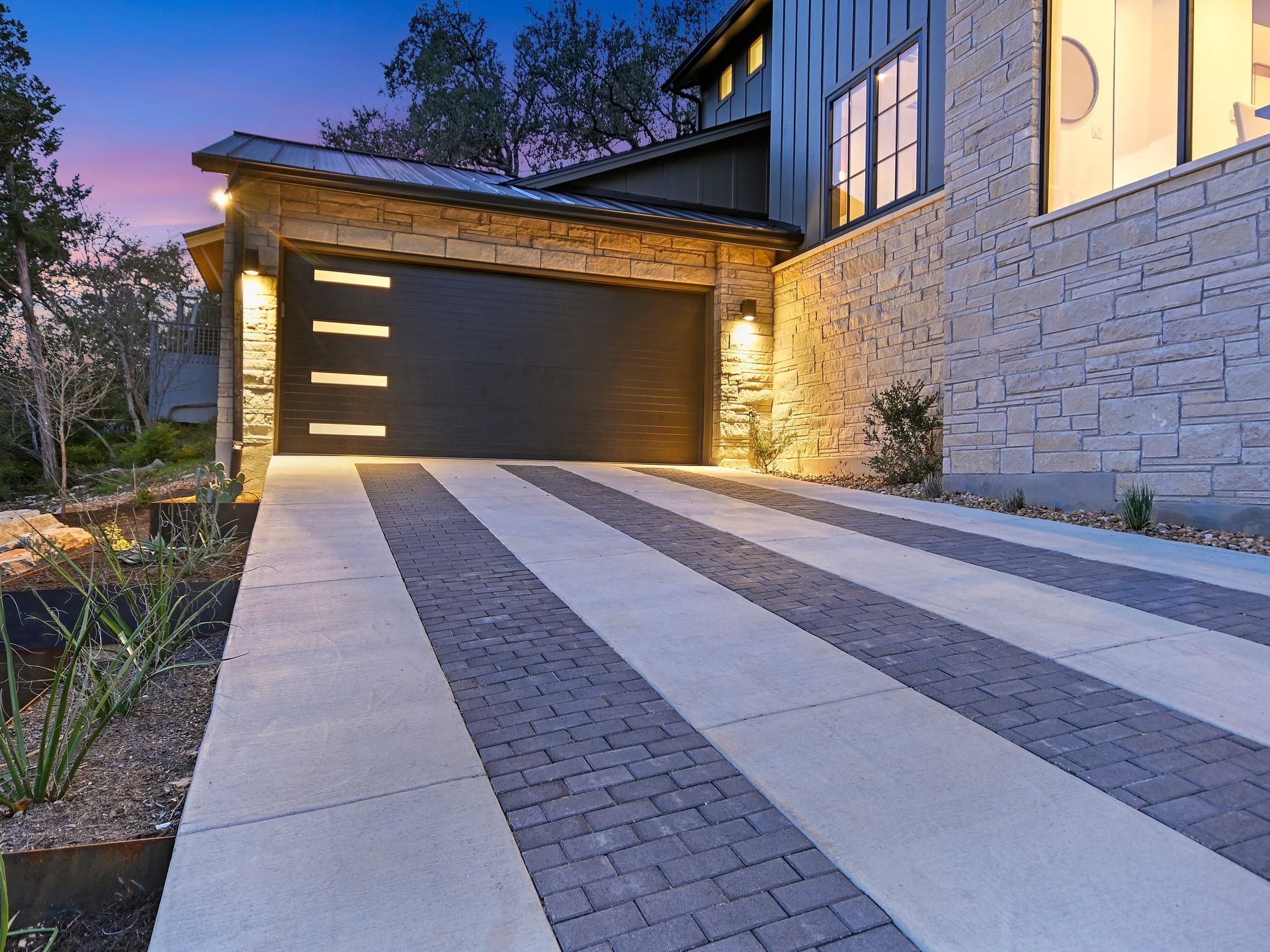 A driveway leading to a garage door of a house.