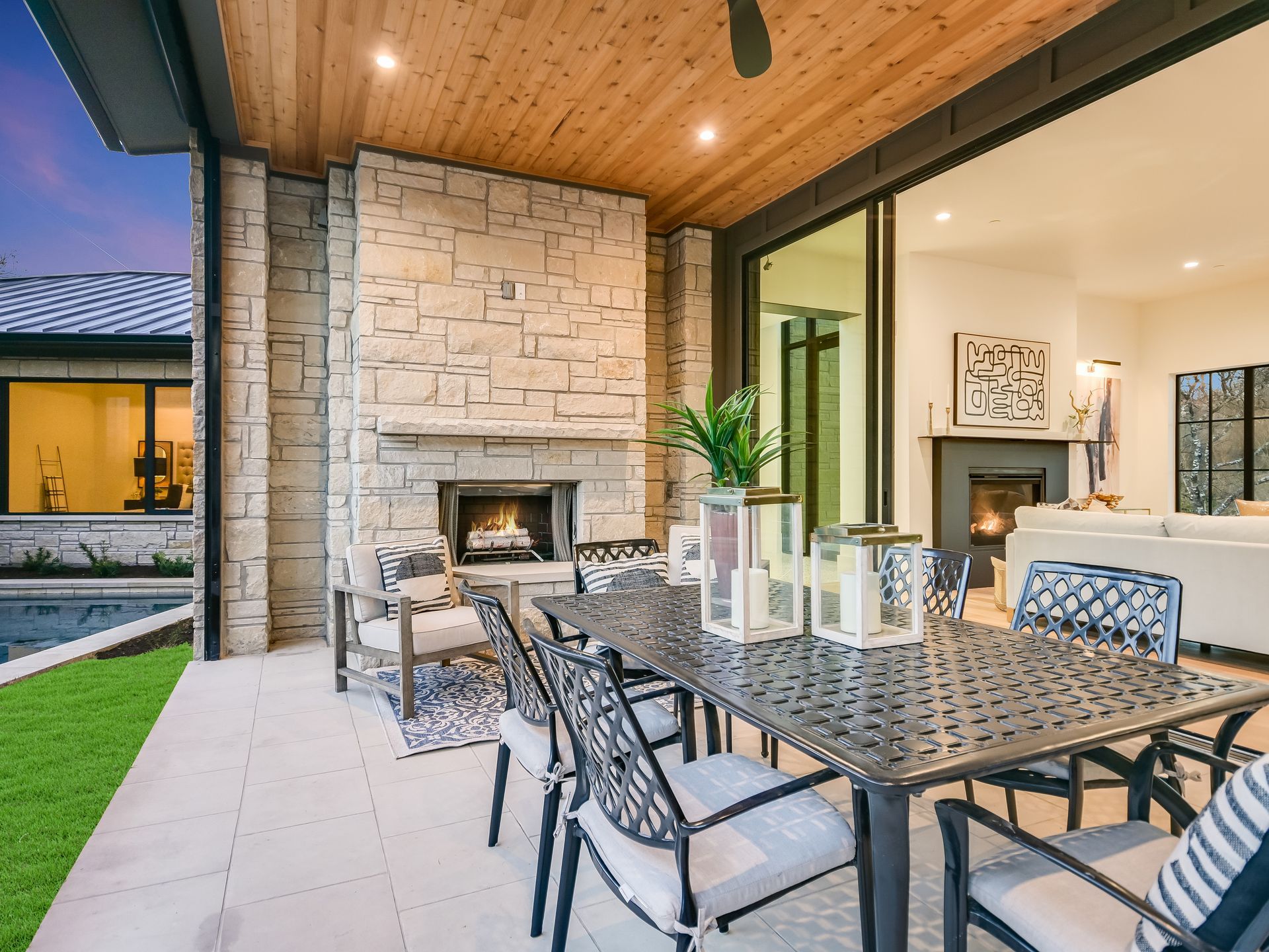 A patio with a table and chairs and a fireplace.