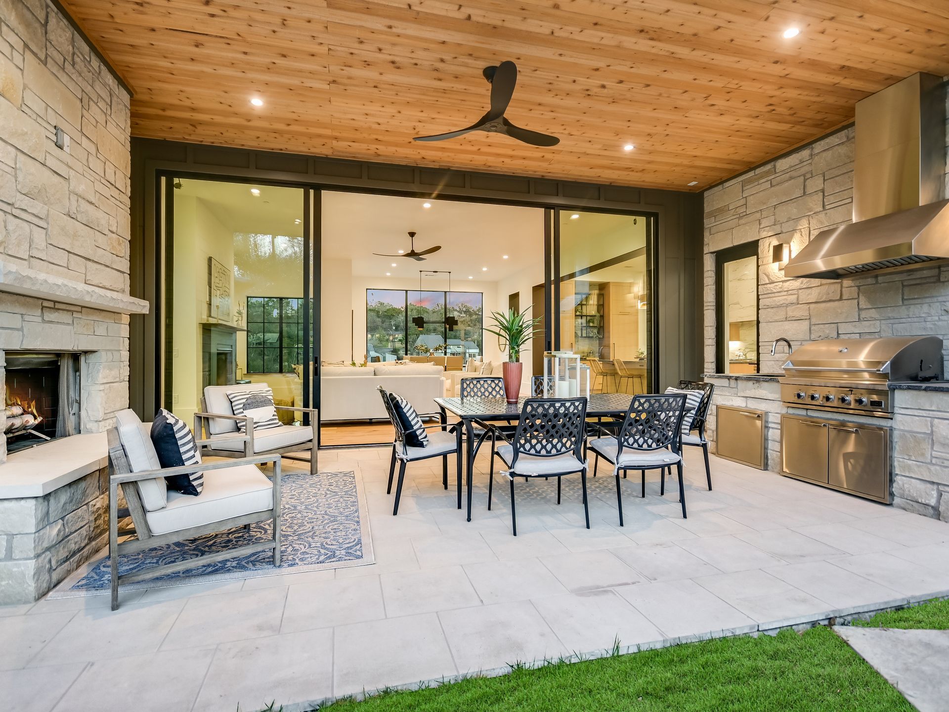 A patio with a table and chairs and a fireplace.