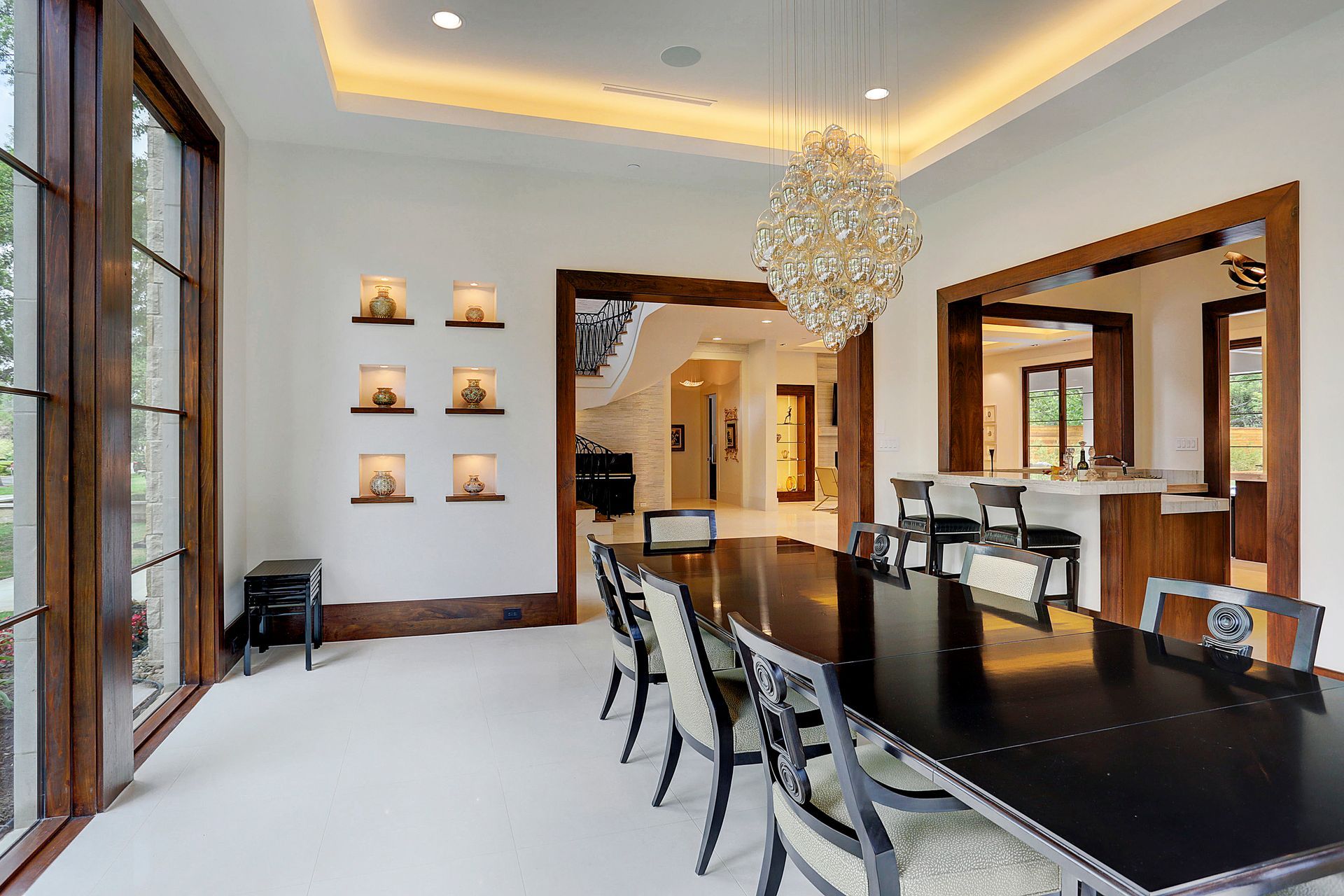 Elegant dining room with chandelier, dark table, light walls, and wooden accents.